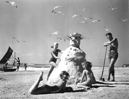 Three girls making a &quot;sandman&quot; at the beach