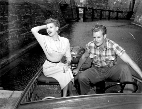 Mari Aldon and Richard Webb sit on a motorboat when visiting the castle during &quot;Distant Drums&quot; premiere: Saint Augustine, Florida